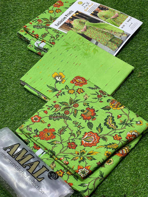 Green floral printed unstitched fabric set from AMAL premium collection with catalog on grass background