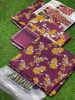 Amal premium unstitched fabric collection with purple and yellow floral prints displayed on green grass