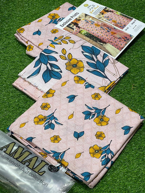 AMAL premium unstitched fabric with yellow and blue floral prints on pink background displayed on green grass