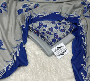 Imported Korkai wool shawl in grey and blue with floral pattern on soft white fur background