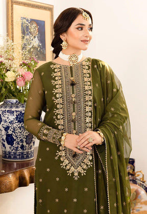 woman wearing olive green embroidered traditional dress with matching dupatta and gold jewelry indoors